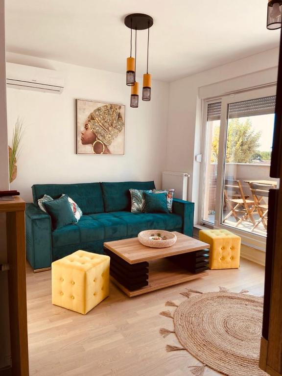 a living room with a blue couch and a table at Jarun Lake in Zagreb