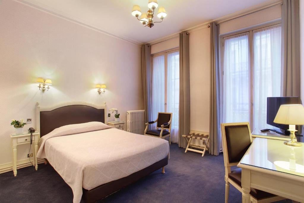 a hotel room with a bed and a desk at HOTEL DU PRINTEMPS in Paris