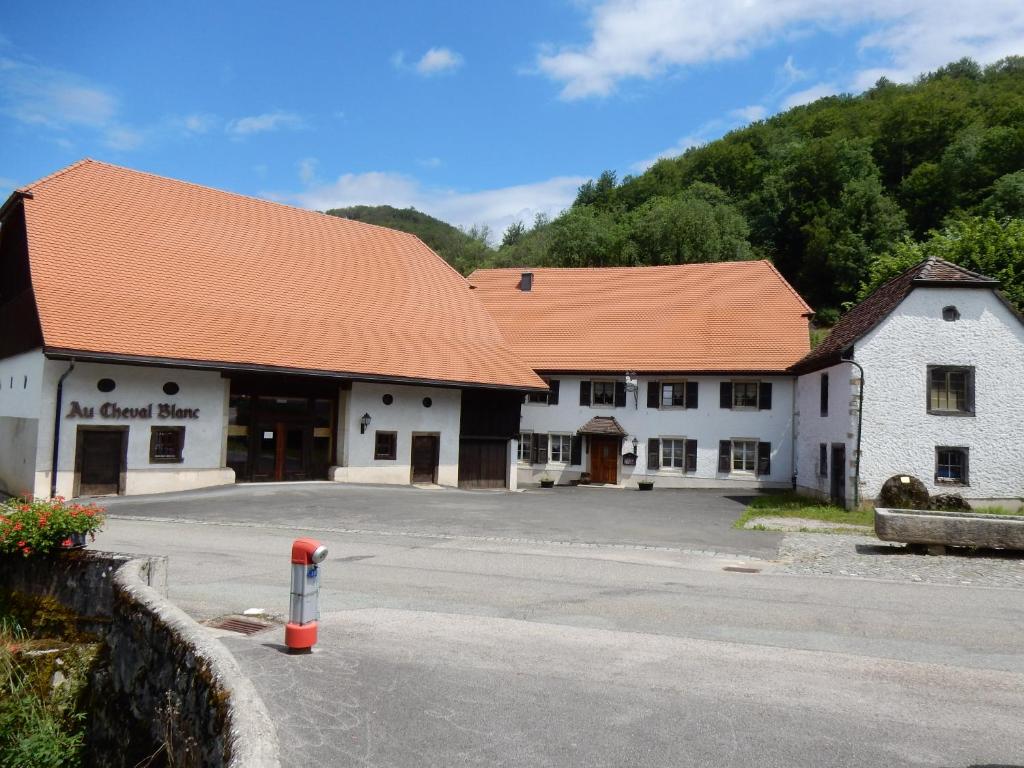 ein großes weißes Gebäude mit orangefarbenem Dach in der Unterkunft Au Cheval Blanc in Asuel