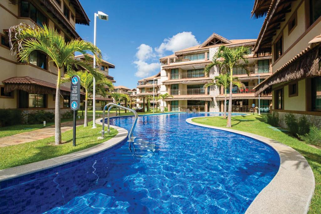 a swimming pool in the middle of a resort at Riviera Beach Place And Manhattan Golf Residence Up to 6 Adults and 3 Children in Aquiraz