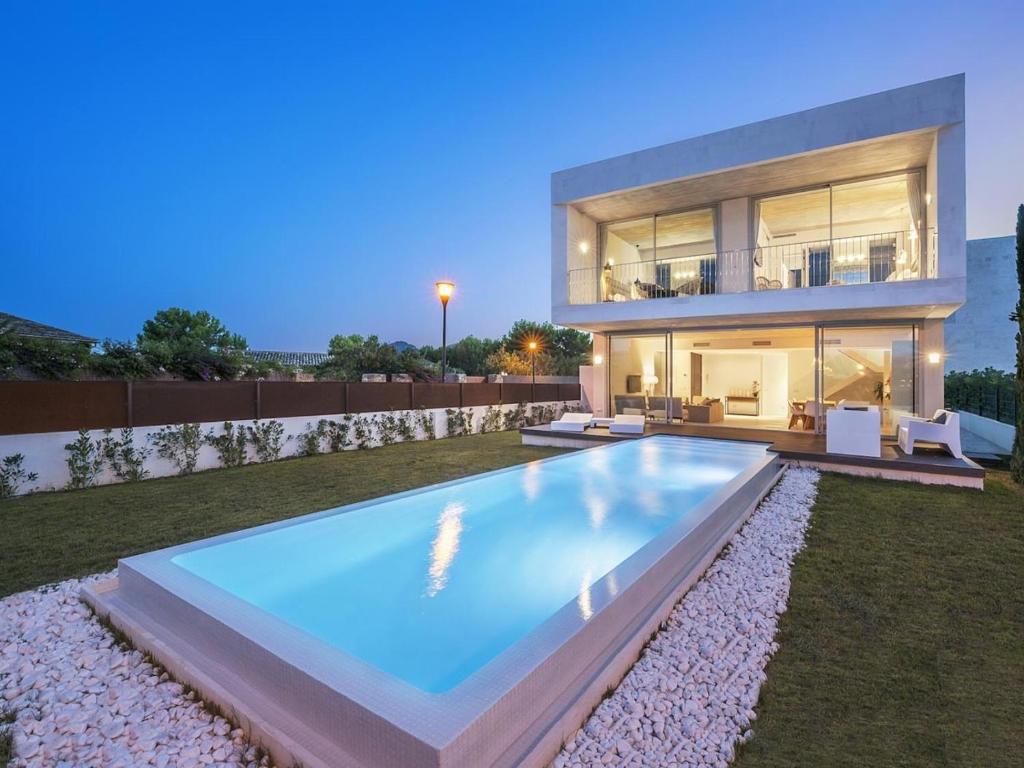une grande piscine en face d'une maison dans l'établissement Villa barcares, à Alcúdia