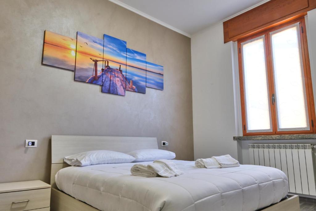 una camera con due letti e due quadri alle pareti di [Milano - Como] Elegante Casa con Ampio Terrazzo a Giussano