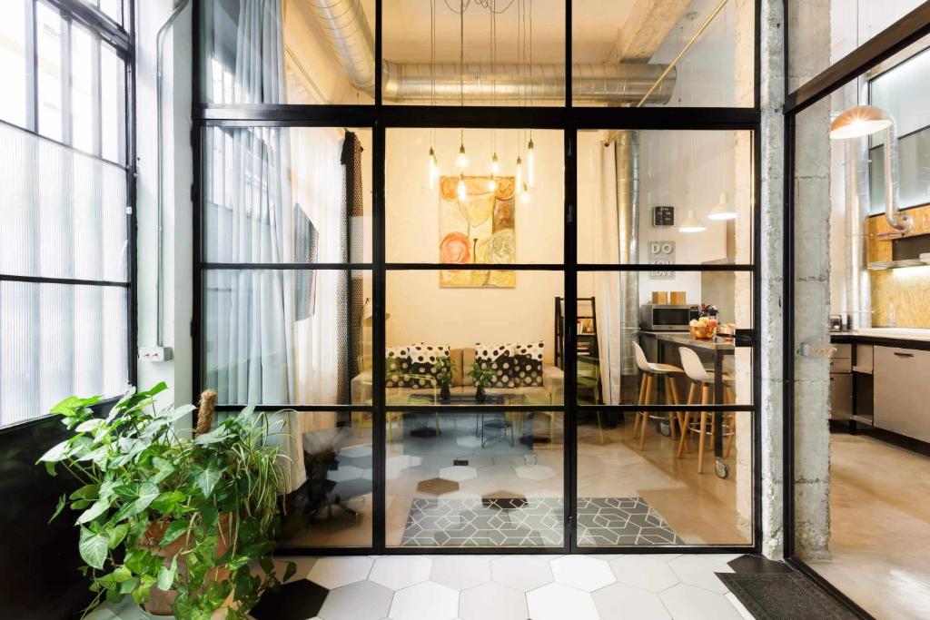 - une grande porte en verre dans une chambre avec une table dans l'établissement MonKeys Apartments Luxury MetaLoft, à Séville
