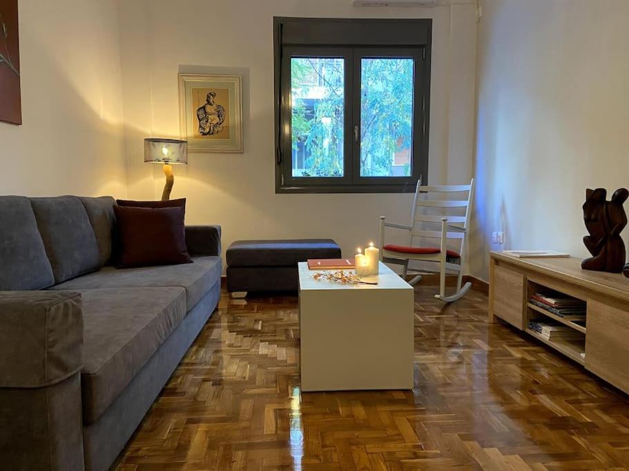 ein Wohnzimmer mit einem Sofa und einem Tisch in der Unterkunft Cozy and comfortable apartment in Athens Center in Athen