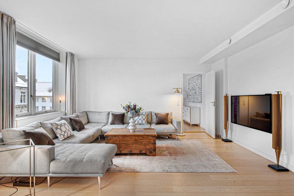 a living room with a couch and a table at Sanders Monarch - Charming One-Bedroom Apartment With Two Balconies in Copenhagen