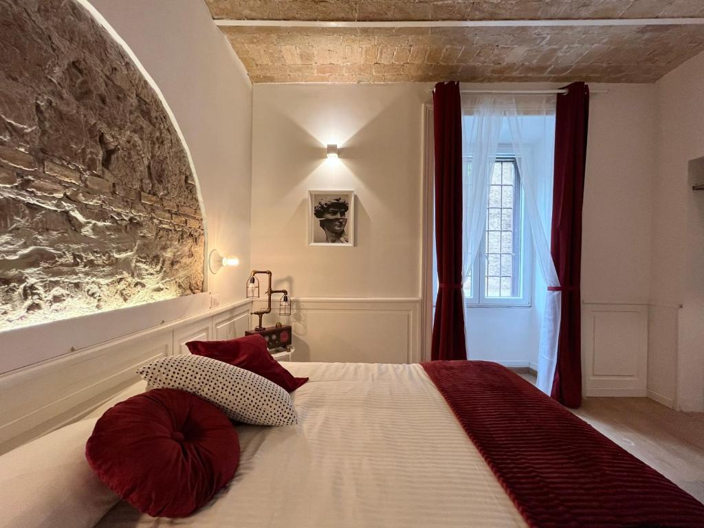 a bedroom with a bed with a stone wall at Domus Avi - Guest House in Rome