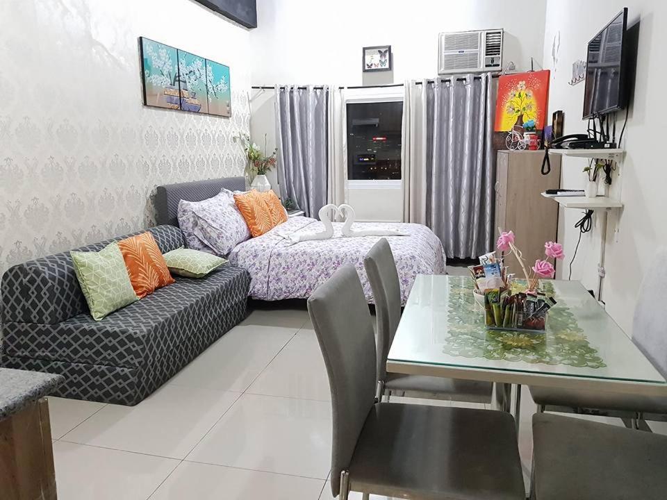 sala de estar con sofá y mesa. en Luxanos Condo Place- San Marino en Cebu City