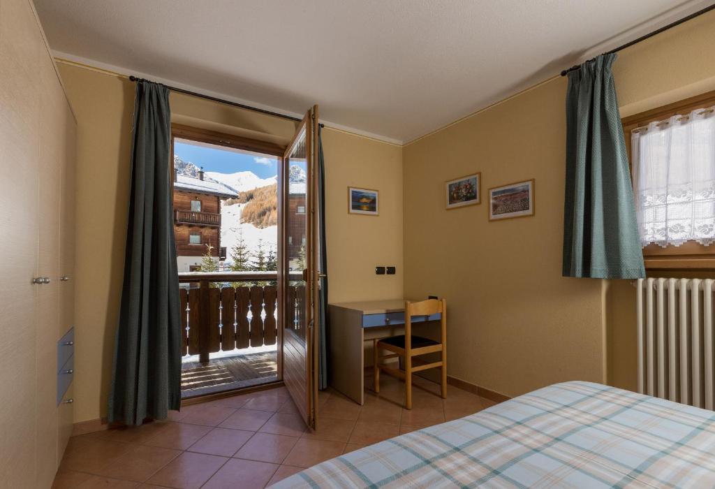 ein Schlafzimmer mit einem Bett und einem Balkon in der Unterkunft Stefano 1 in Livigno