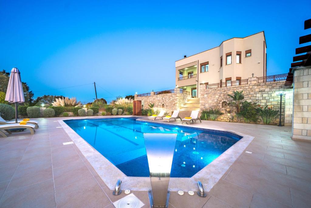 a swimming pool in front of a building at Iremia Luxury Villa with pool in  Episkopi (Chania)