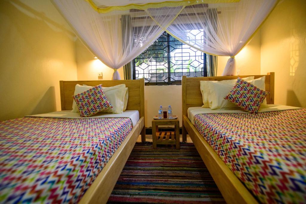 Postel nebo postele na pokoji v ubytování Cycad Entebbe Guest House