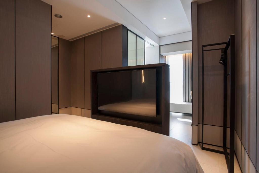 a bedroom with a bed and a glass wall at Manho Hotel in Taichung