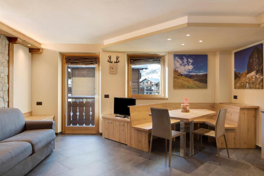 a living room with a table and a couch at Rasia Residence Relax Stone in Livigno