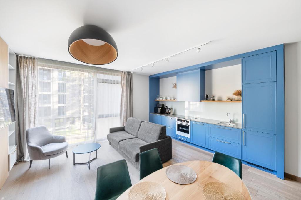 een woonkamer met blauwe kasten en een tafel bij SoulHouse apartments in Druskininkai