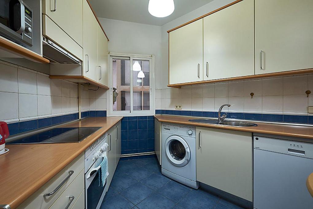 a kitchen with a sink and a washing machine at Santo Domingo Rooms in Madrid