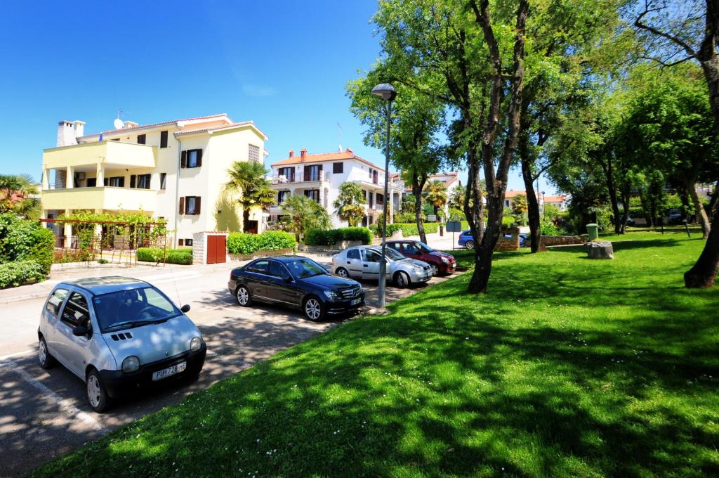 un grupo de autos estacionados en un estacionamiento en Apartments Jasmina, en Poreč