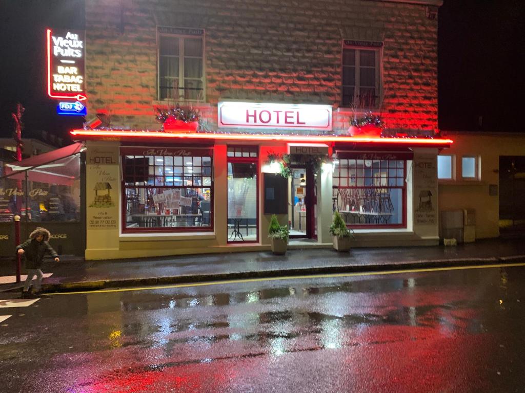 um hotel numa rua da cidade à noite em Au Vieux Puits em Villers-Bocage