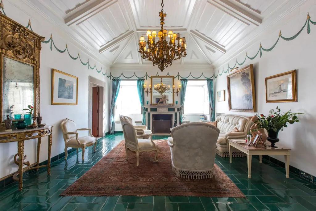 sala de estar con muebles y lámpara de araña. en Casa Picva, en Óbidos