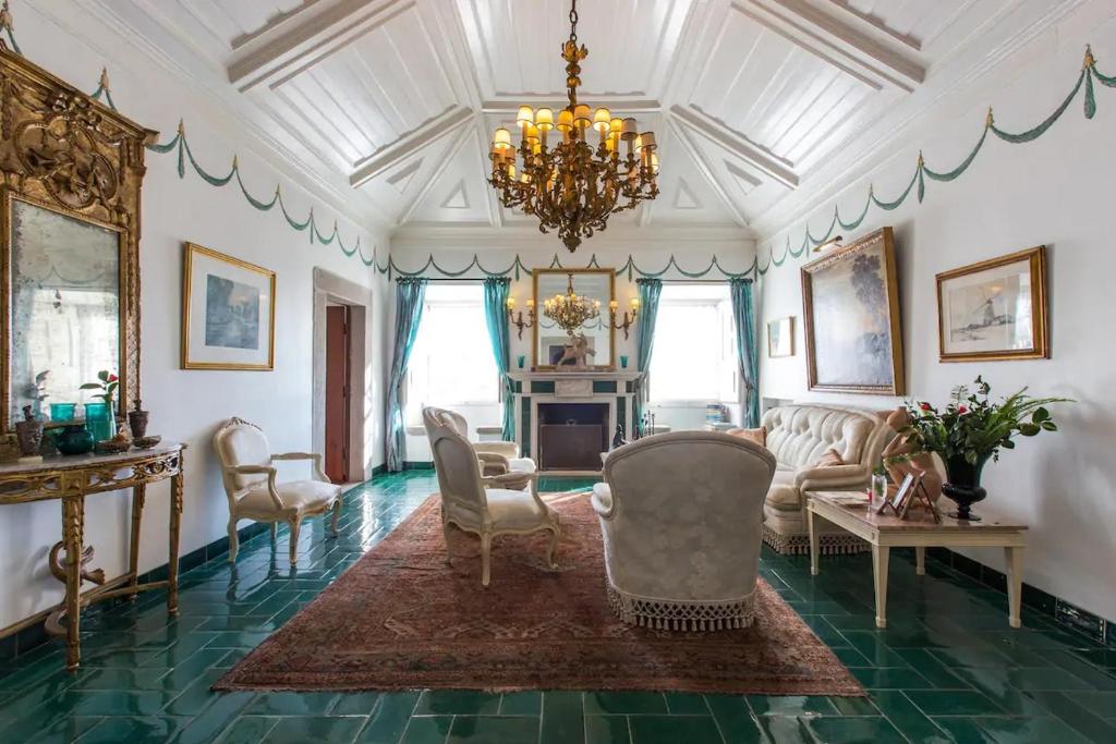 uma sala de estar cheia de mobiliário e um lustre em Casa Picva em Óbidos