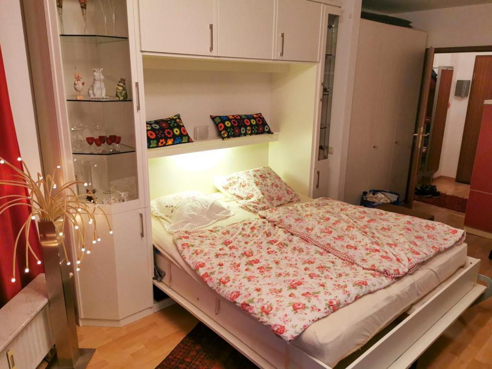 Dormitorio pequeño con cama con manta de flores en Fewo-Strandmaennchen, en Dahme