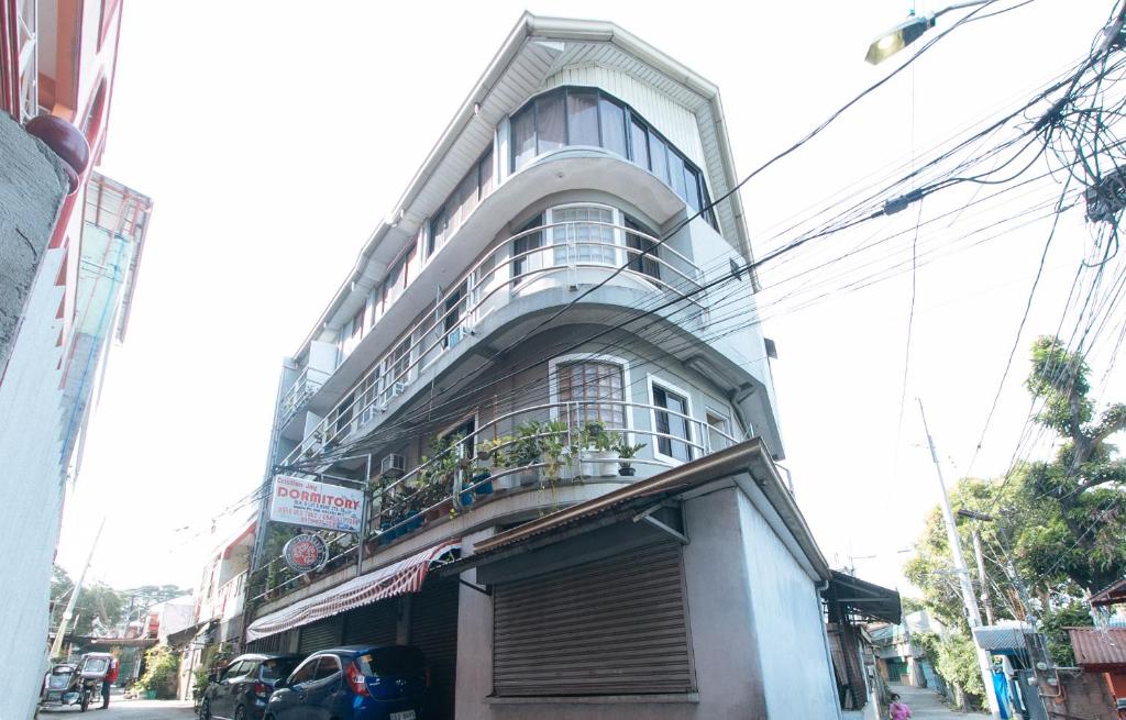 ein hohes Gebäude mit Balkon darüber in der Unterkunft Cristian Jay Dormitory by RedDoorz in Dasmariñas