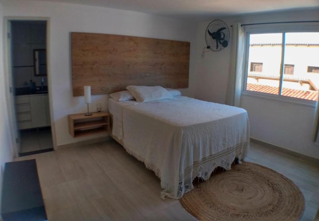 a bedroom with a bed and a large window at Apartamento Duplex beira Mar in Nísia Floresta