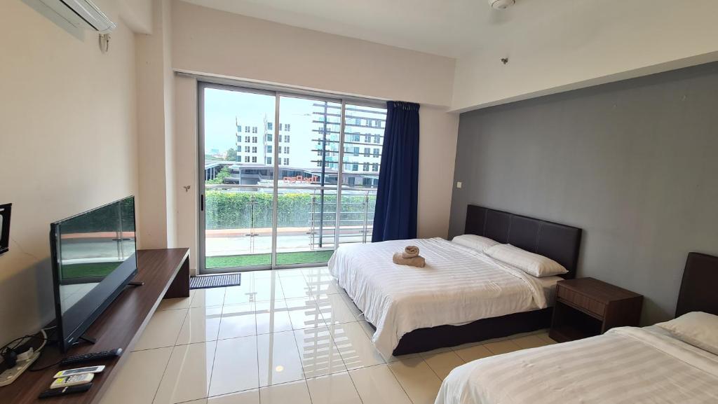 a bedroom with two beds and a flat screen tv at KK Aeropod Corner unit A near Airport and City Free Parking in Kota Kinabalu