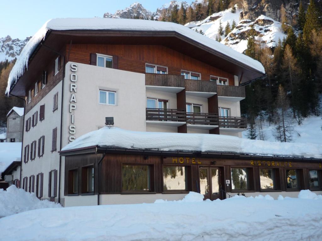 un hotel con nieve en el suelo delante de él en Appartamenti Sorapiss en Misurina