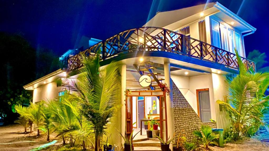 a white house with a balcony on the side of it at String Wave Maldives in Gulhi