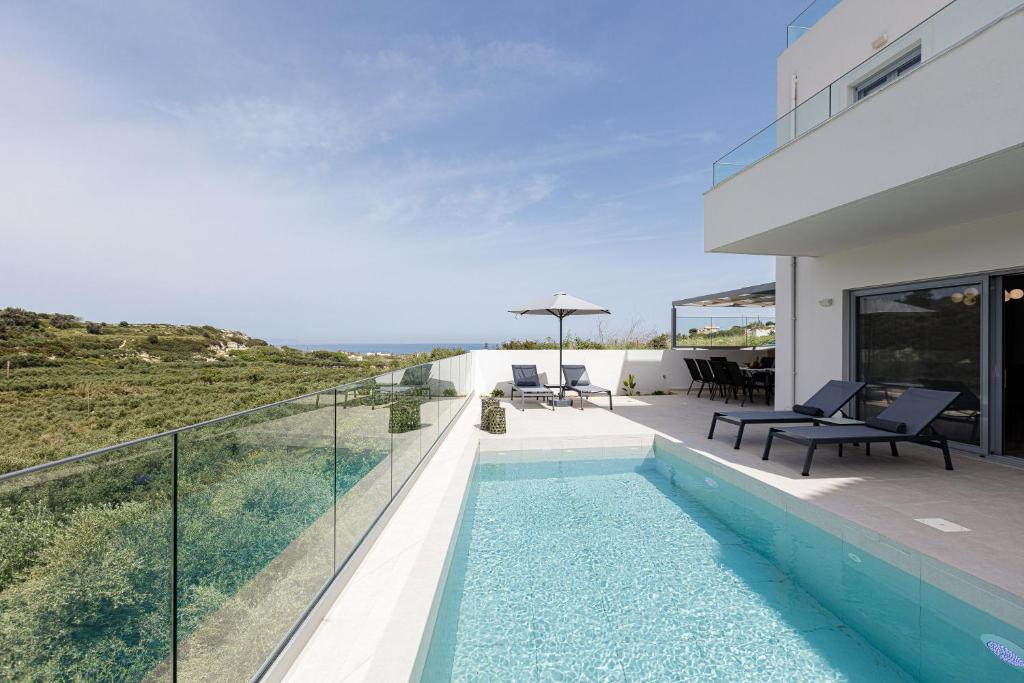 a swimming pool on the balcony of a house at Blue Aura Villa, elegance & calm living, By ThinkVilla in Magnisía