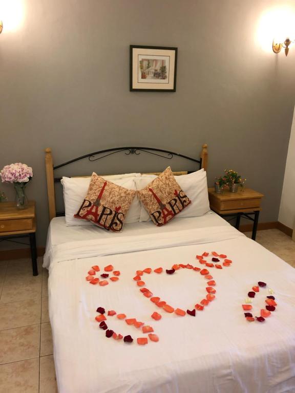 Una cama con un corazón hecho de rosas en Bukit Tinggi Berjaya Hill Homestay en Bukit Tinggi
