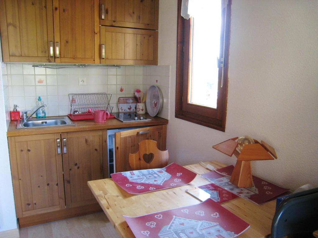 cocina con armarios de madera y mesa de madera en Appartement d'une chambre a Bernex a 50 m des pistes avec balcon et wifi, en Bernex