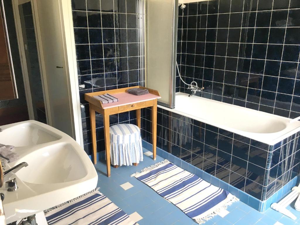 a blue tiled bathroom with a tub and a sink at Maison de 7 chambres avec vue sur le lac jardin clos et wifi a Le Dezert in Montmartin-en-Graignes