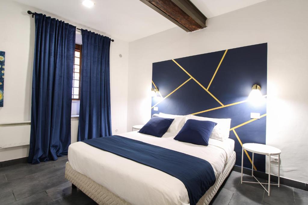 a bedroom with a large bed with a blue and gold headboard at Charming Large Apartment - 3 Bedroom in Trastevere in Rome