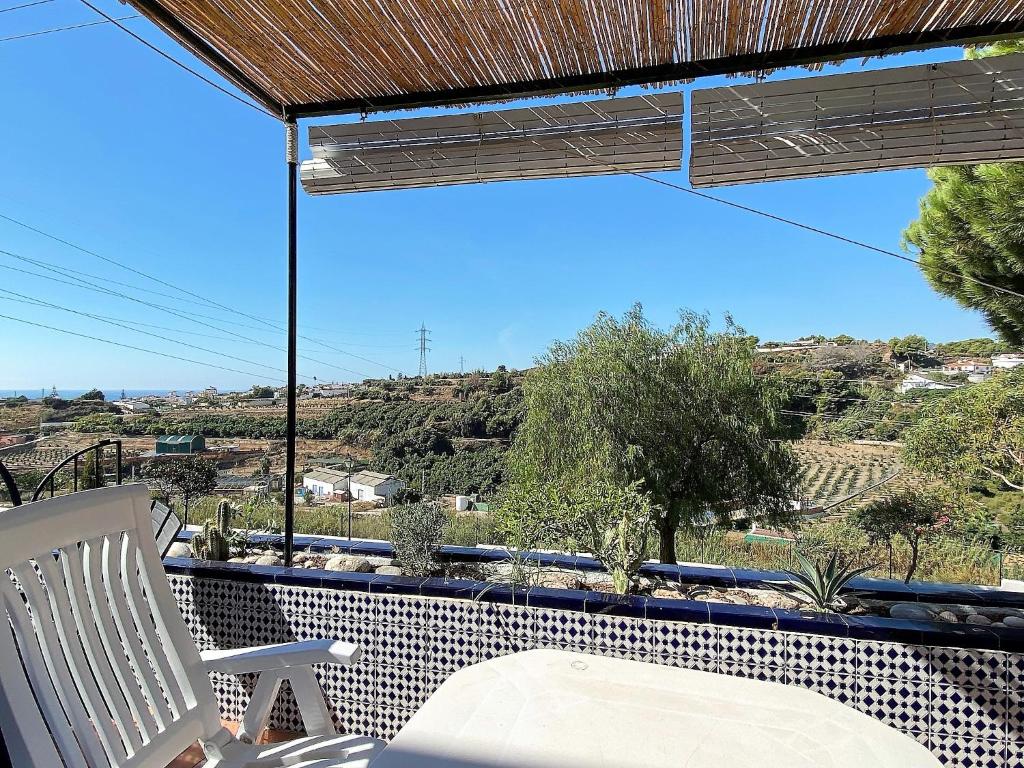 une chaise blanche assise sur un balcon avec vue dans l'établissement Casa Almijara Casasol, à Nerja