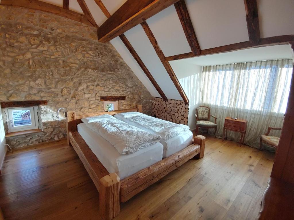 um quarto com uma cama e uma parede de pedra em Landgasthof Roderis em Nunningen