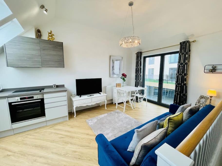 a living room with a blue couch and a tv at Salt Yard 2 - Stylish Whitstable Cottage - Free Parking - Beach - Harbour in Whitstable