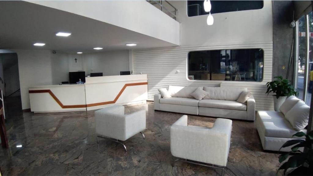 - un salon avec un canapé, des chaises et un bureau dans l'établissement Hotel Ipanema Inn Higienópolis, à São Paulo