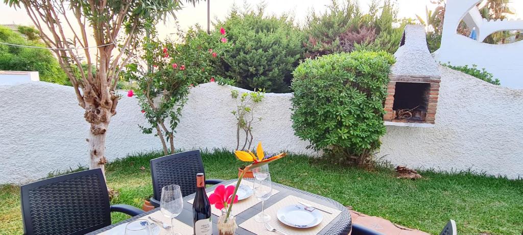 uma mesa com flores no jardim em Casa Neptuno Spainsunrentals 1205 em Nerja