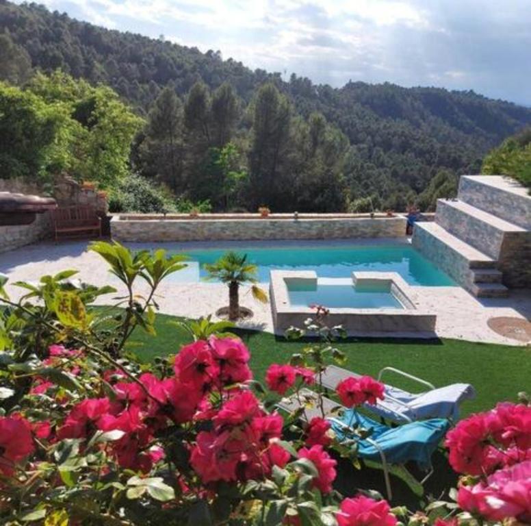 basen w ogrodzie z różowymi kwiatami w obiekcie Cal Abadal - Double room in villa with pool and jacuzzi near Barcelona w mieście Rocafort