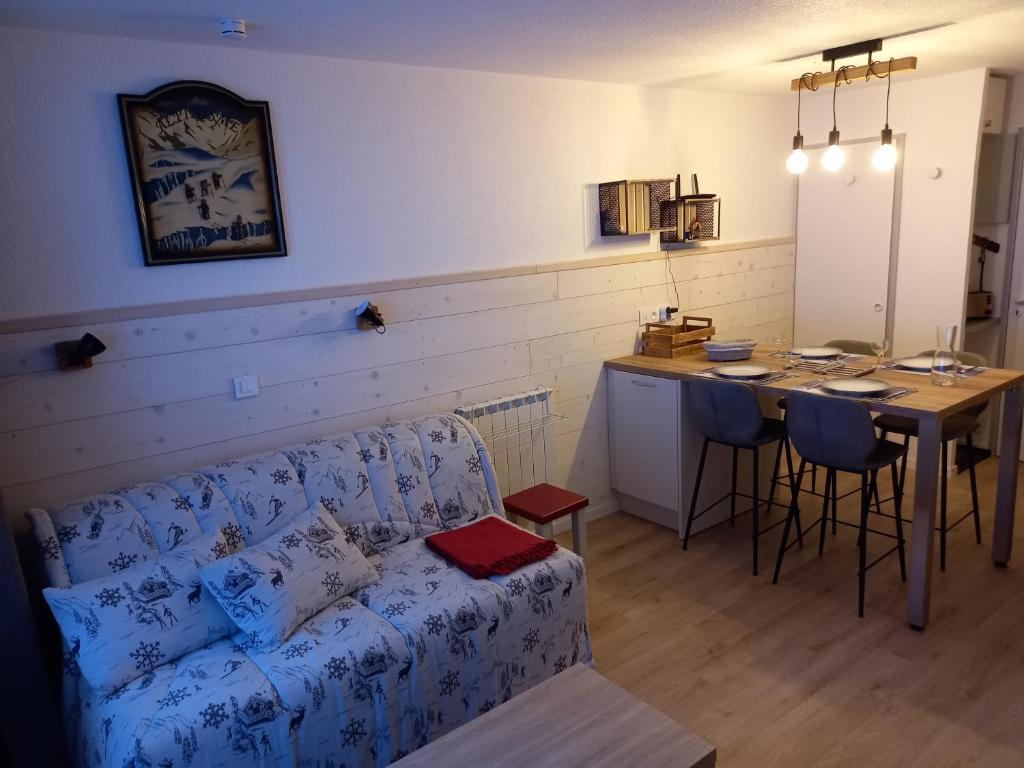 sala de estar con sofá y mesa en La Plagne Les Coches studio divisible ensoleillé, en La Plagne Tarentaise