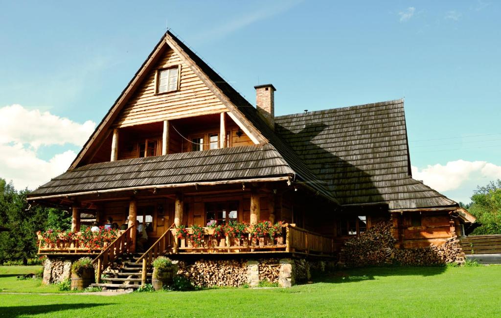 a large wooden house with a gambrel roof at Willa Stasia in Ustrzyki Dolne