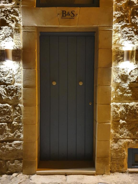 a blue door in a stone building at B&S Accommodation Renovated 18 Century House of Character in Ghaxaq in Hal Ghaxiak