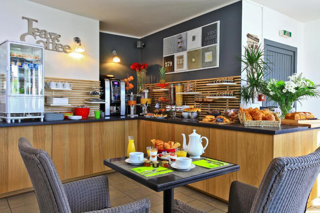 a cafe with a table and a counter with food at Logis Hôtel La Chaize in Noirmoutier-en-l'lle