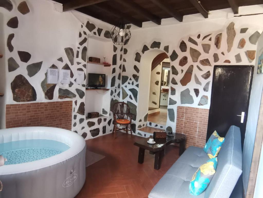 a living room with a tub in the middle of a room at Casita Rural con Jacuzzi climatizado. in Los Realejos