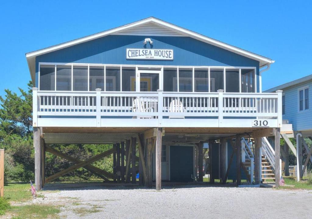 a large house with a porch on top of it at Chelsea House in Oak Island