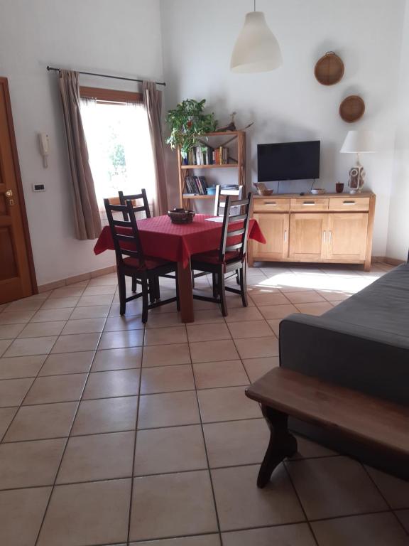 een woonkamer met een tafel en stoelen en een televisie bij Il Pesco in Nus