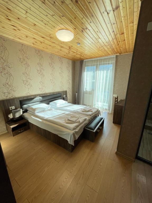 a bedroom with a large bed and a wooden ceiling at Hotel Elite House in Mestia
