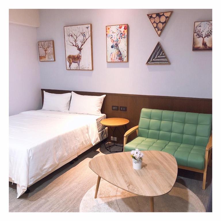 a bedroom with a bed and a couch and a table at SUN 9 Inn in Hengchun South Gate