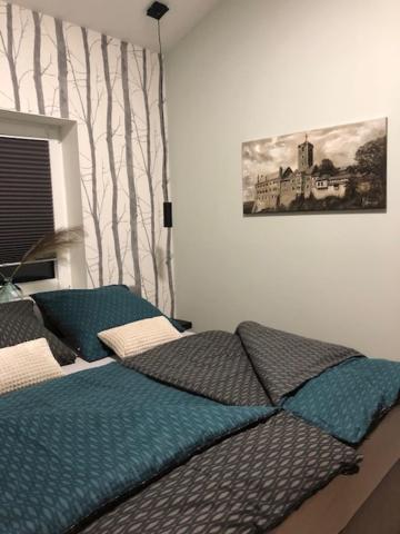 łóżko w sypialni z obrazem na ścianie w obiekcie Waldfrieden Ferienhaus mit SAUNA w mieście Ruhla