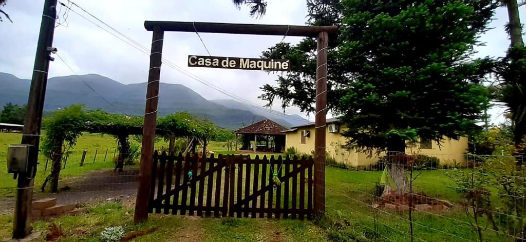 a gate to a house with a sign that reads magic machine at Casa de Maquiné in Maquiné